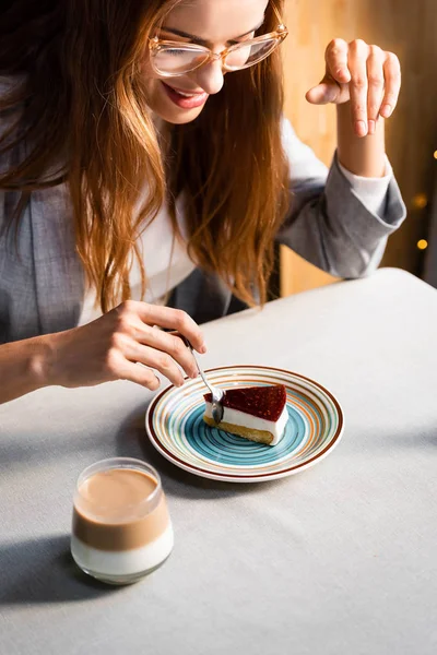 Glückliche schöne Frau isst Kuchen mit Kaffee im Café — Stockfoto