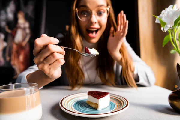 Surpris belle femme manger gâteau avec café dans le café — Photo de stock