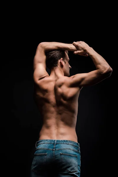 Rear view of handsome shirtless man posing isolated on black — Stock Photo