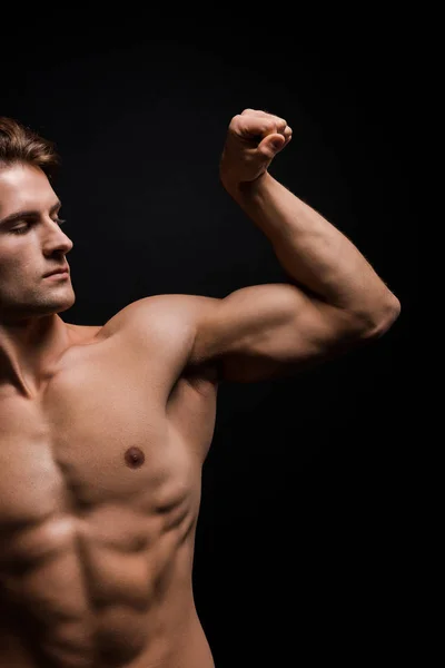 Красивый мужчина без рубашки показывает мышцы изолированы на черном — стоковое фото