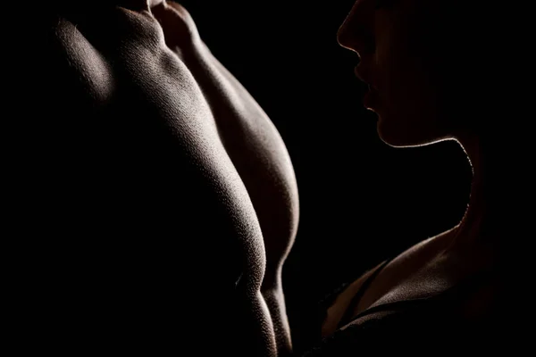 Ausgeschnittene Ansicht eines verführerischen Paares, das sich umarmt, isoliert auf schwarz mit Hintergrundbeleuchtung — Stockfoto