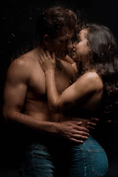 Beau couple passionné étreignant et embrassant derrière verre mouillé — Stock Photo
