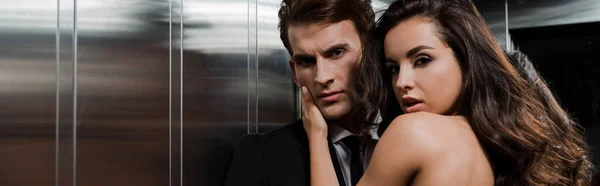 Beau couple sensuel étreignant et flirtant dans l'ascenseur — Photo de stock