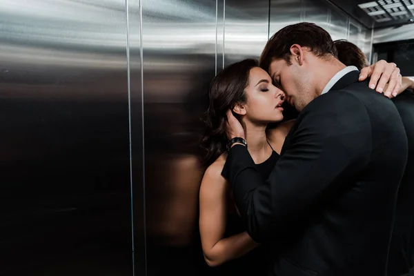 Beau couple passionné câlin et aller embrasser dans ascenseur — Photo de stock