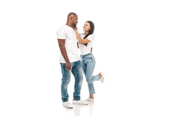 Cheerful african american woman touching face of handsome husband on white background — Stock Photo