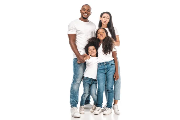 Alegre africano americano madre y hija haciendo pato caras mientras de pie cerca padre e hijo en blanco fondo - foto de stock