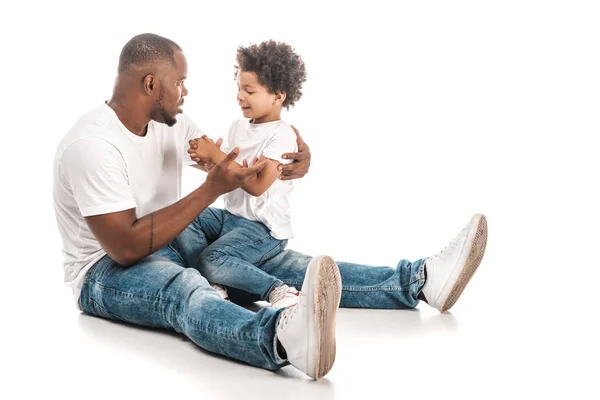 Bel homme afro-américain parlant à adorable fils sur fond blanc — Photo de stock