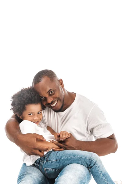 Heureux homme afro-américain embrassant adorable fils et regardant caméra isolé sur blanc — Photo de stock