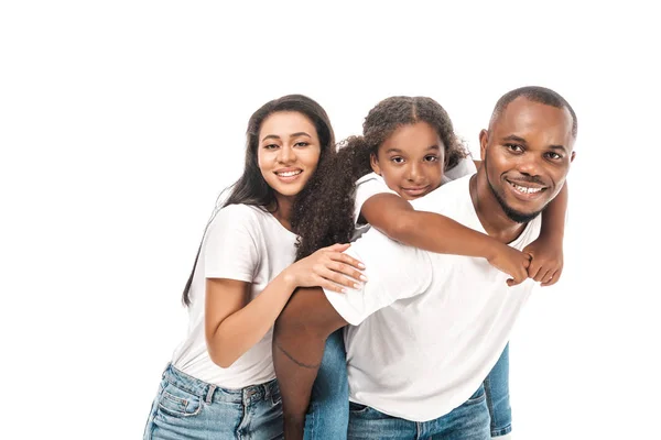 Happy african american man piggybacking daughter near smiling wife isolated on white — Stock Photo
