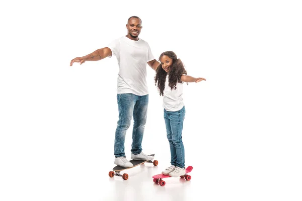 Alegre afro-americano pai e filha balanceamento no longboard e skate no fundo branco — Fotografia de Stock