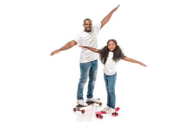 Feliz afro-americano pai e filha balanceamento no longboard e skate no fundo branco — Fotografia de Stock