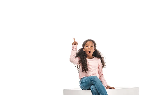 Aufgeregtes afrikanisch-amerikanisches Kind zeigt Ideenschild, während es isoliert auf weiß sitzt — Stockfoto