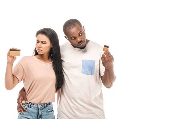 Couple afro-américain sceptique regardant les cartes de crédit isolées sur blanc — Photo de stock