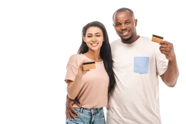 Sorrindo casal afro-americano segurando cartões de crédito e olhando para a câmera isolada no branco — Fotografia de Stock