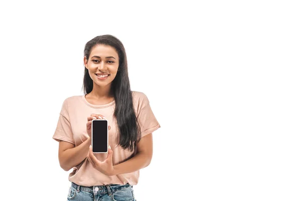 Alegre mujer afroamericana sosteniendo teléfono inteligente con pantalla en blanco aislado en blanco - foto de stock