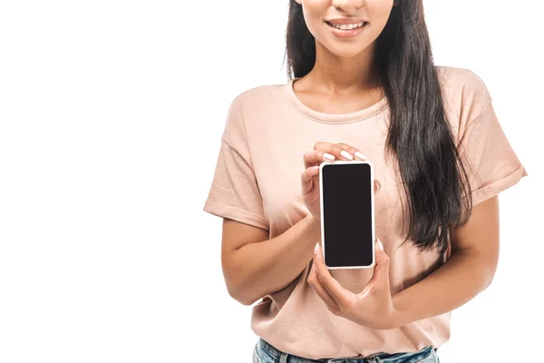 Vista parcial de la sonriente mujer afroamericana sosteniendo teléfono inteligente con pantalla en blanco aislado en blanco - foto de stock