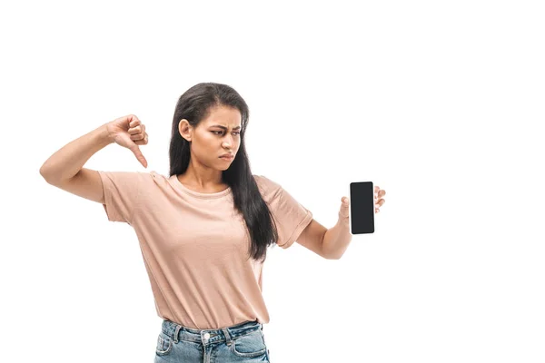 Mujer afroamericana insatisfecha sosteniendo teléfono inteligente con pantalla en blanco y mostrando el pulgar hacia abajo aislado en blanco - foto de stock