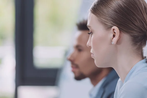 Selective focus of young businesswoman near african american colleague — Stock Photo