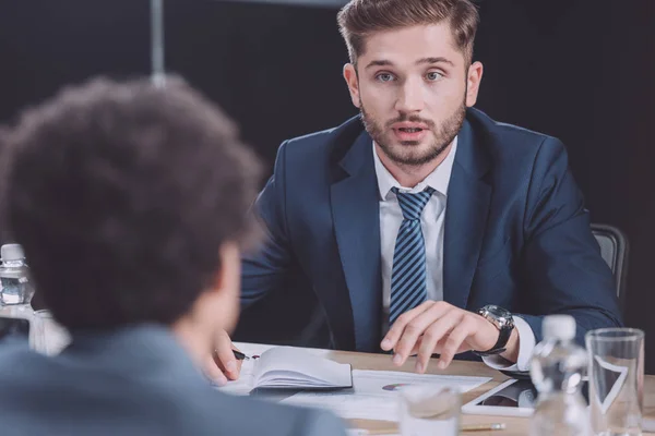 Enfoque selectivo de los jóvenes empresarios hablando en la reunión de negocios - foto de stock