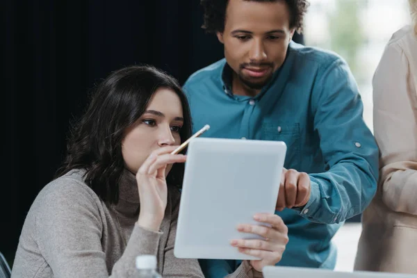 Attractive businesswoman holding digital tablet near african american businessman — Stock Photo