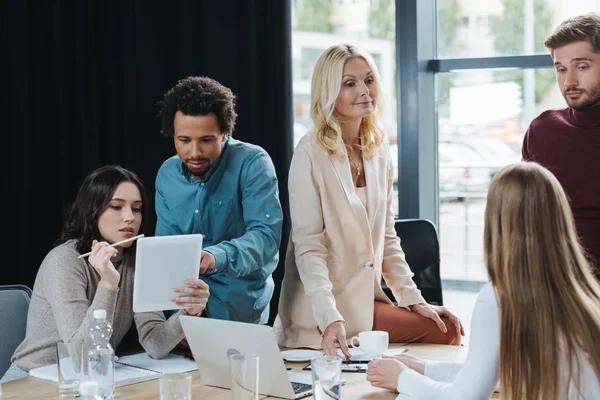 Young multicultural businesspeople discussing business ideas during meeting in office — Stock Photo