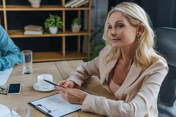 Attrayant, femme d'affaires mature assis au bureau dans la salle de réunion — Photo de stock