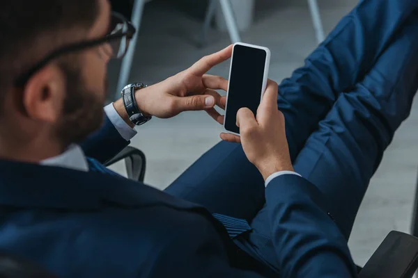 Enfoque selectivo de hombre de negocios que sostiene el teléfono inteligente con pantalla en blanco - foto de stock