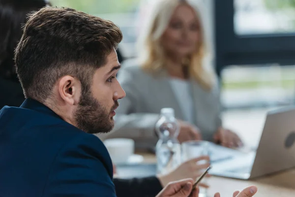 Foco seletivo do jovem empresário conversando em reunião de negócios — Fotografia de Stock