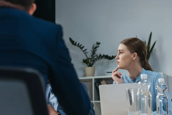 Уважна бізнес-леді слухає колег під час ділової зустрічі в офісі — стокове фото