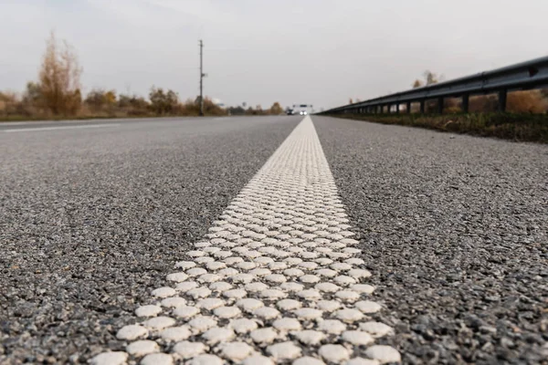 Foco seletivo da pista no asfalto cinzento na estrada vazia — Fotografia de Stock