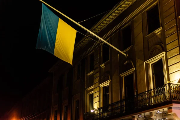 Низкий угол обзора украинского флага возле древнего здания во Львове — стоковое фото