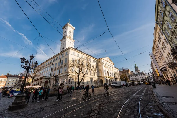 LVIV, UKRAINE - OCTOBER 23, 2019: people and vehicles near lviv city hall — Stock Photo