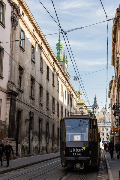 LVIV, UKRAINE - 23. OKTOBER 2019: Straßenbahn mit Uklon-Schriftzug auf enger Straße in der Innenstadt — Stockfoto