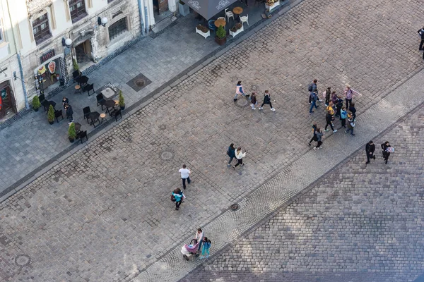 LVIV, UKRAINE - 23. OKTOBER 2019: Luftaufnahme von Menschen, die an Straßencafés entlang gehen — Stockfoto