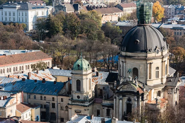 LVIV, UKRAINE - 23. OKTOBER 2019: Luftaufnahme der Dominikanerkirche mit lateinischen Schriftzügen, umgeben von grünen Bäumen — Stockfoto