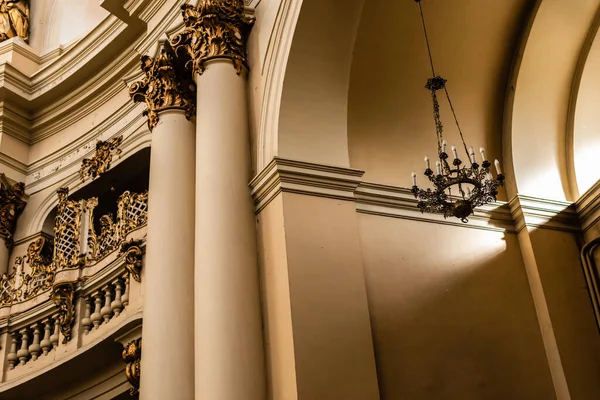 LVIV, UCRAINA - 23 OTTOBRE 2019: lampadario, balcone con balaustra e colonne con decorazione dorata nella chiesa dominicana — Foto stock