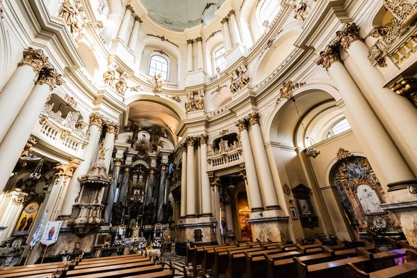 LVIV, UCRANIA - 23 DE OCTUBRE DE 2019: interior de la iglesia dominicana con columnas, balcones y ventanas con decoración dorada - foto de stock