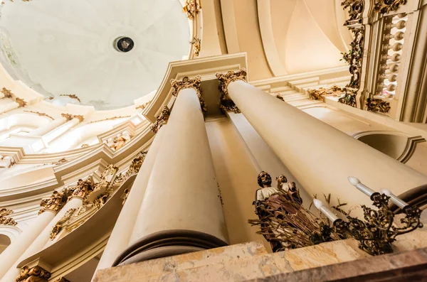 LVIV, UCRÂNIA - OUTUBRO 23, 2019: visão inferior da estátua masculina entre colunas na igreja dominicana — Stock Photo