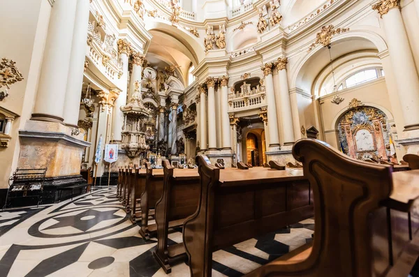 LVIV, UCRÂNIA - OUTUBRO 23, 2019: interior da igreja dominicana com bancos de madeira, piso em mosaico e decoração dourada — Fotografia de Stock