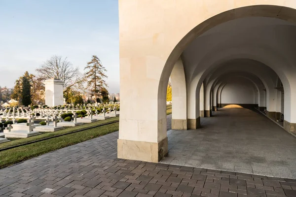 LVIV, UCRAINA - 23 OTTOBRE 2019: galleria di archi e tombe lucide con croci di pietra nel cimitero di lychakiv a lviv, Ucraina — Foto stock