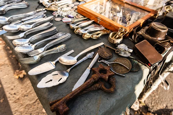 Stall on flea market with vintage cutlery, rusty keys, camera and souvenirs in lviv, ukraine — Stock Photo