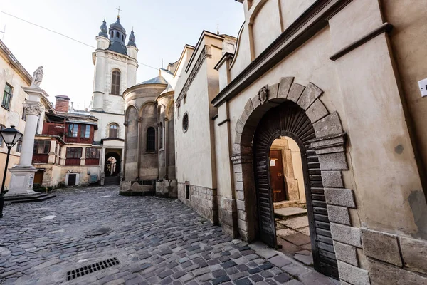 Calle que conduce a la iglesia de carmelita y la pared del monasterio con arco en lviv, Ucrania - foto de stock