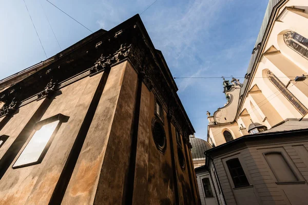 Vista de ángulo bajo de los edificios medievales contra el cielo azul en lviv, Ucrania — Stock Photo