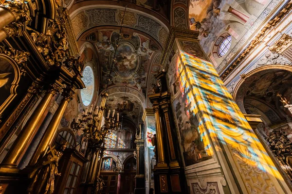 LVIV, UCRANIA - 23 de octubre de 2019: vista de bajo ángulo del interior con pinturas y decoración dorada en la iglesia de carmelita - foto de stock