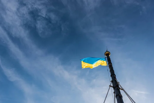 Low angle view of ukrainian flag on flagpole against blue sky in lviv, ukraine — Stock Photo