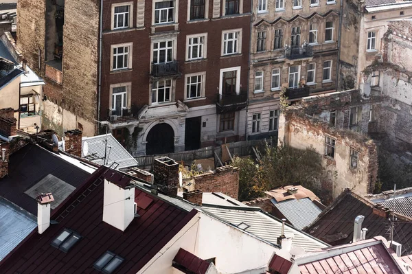 Vista aérea de edificios antiguos y árboles cerca de ruinas de casas en lviv, Ucrania - foto de stock