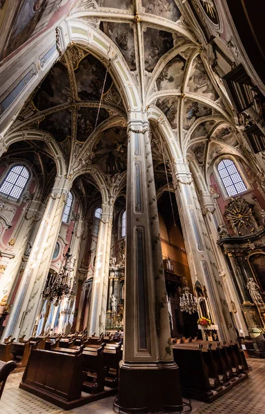 LVIV, UCRANIA - 23 DE OCTUBRE DE 2019: inerior de la catedral latina lviv con bancos de madera, columnas y cúpula - foto de stock