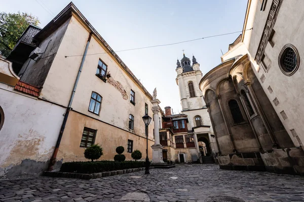 Rue avec vieilles maisons menant à l'église carmélite à Lviv, ukraine — Photo de stock