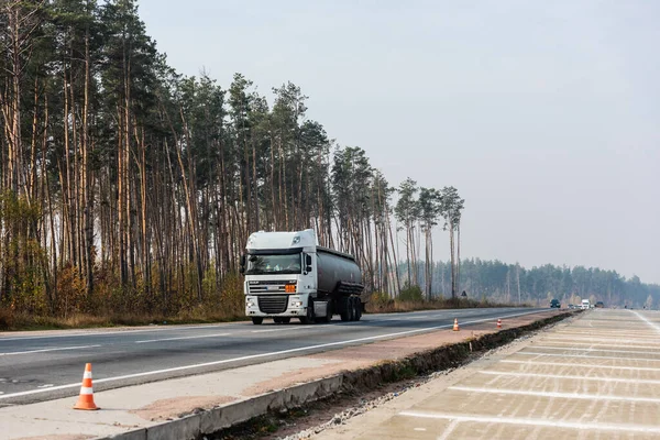 LVIV, UKRAINE - 23 OCTOBRE 2019 : camion avec citerne et inscription sourde se déplaçant sur l'autoroute le long des arbres — Photo de stock
