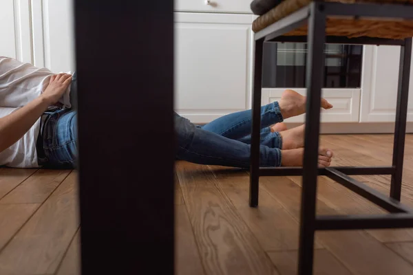 Cropped view of sexy couple lying on floor at home — Stock Photo